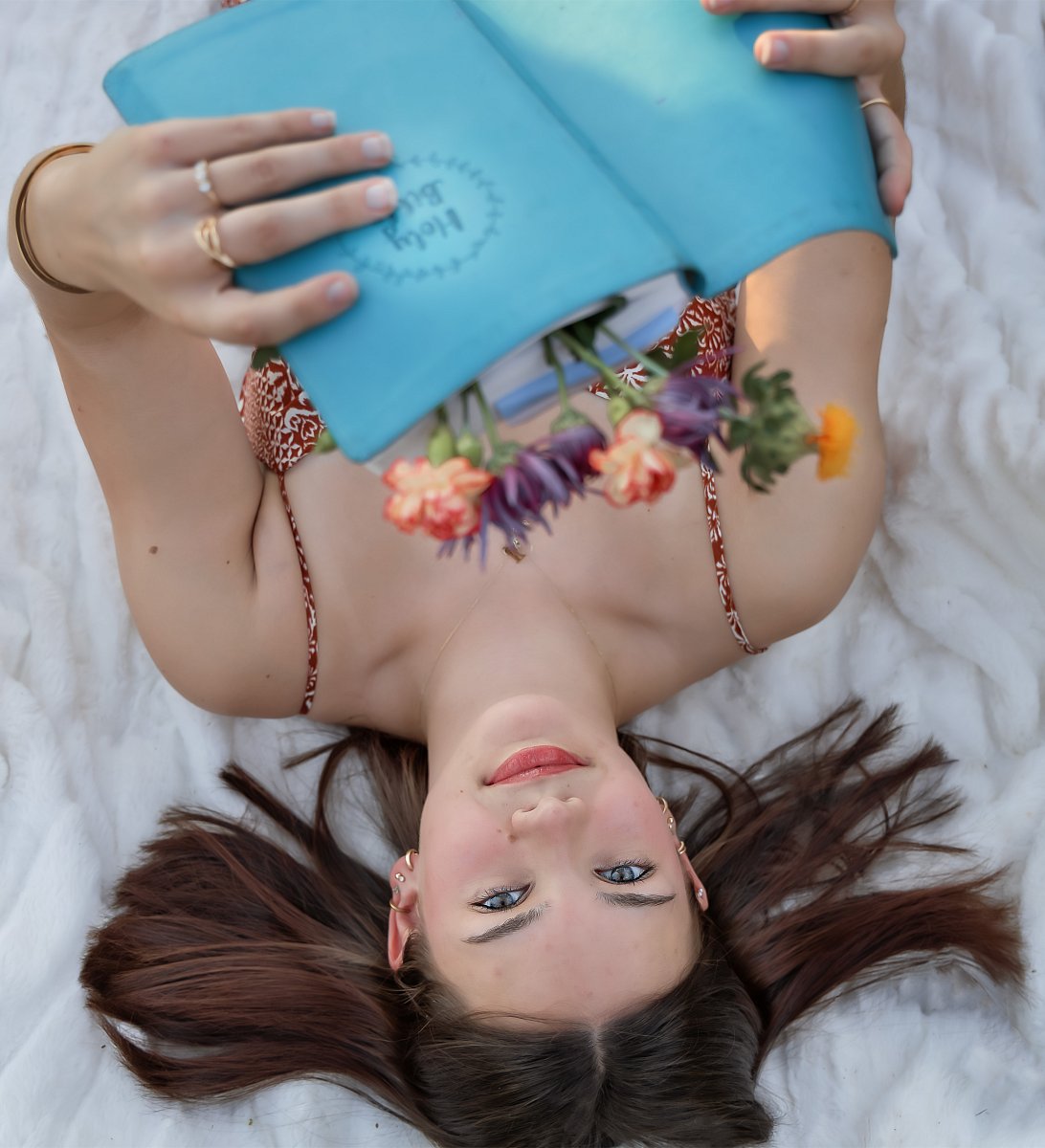 North Little Rock senior portrait photographer — high school senior lying in wildflower field with soft dreamy light, Liza Jane Photography